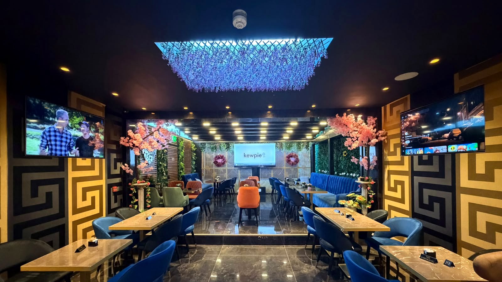 Inside Oltian in Hendon, with blue seating and hanging flowers