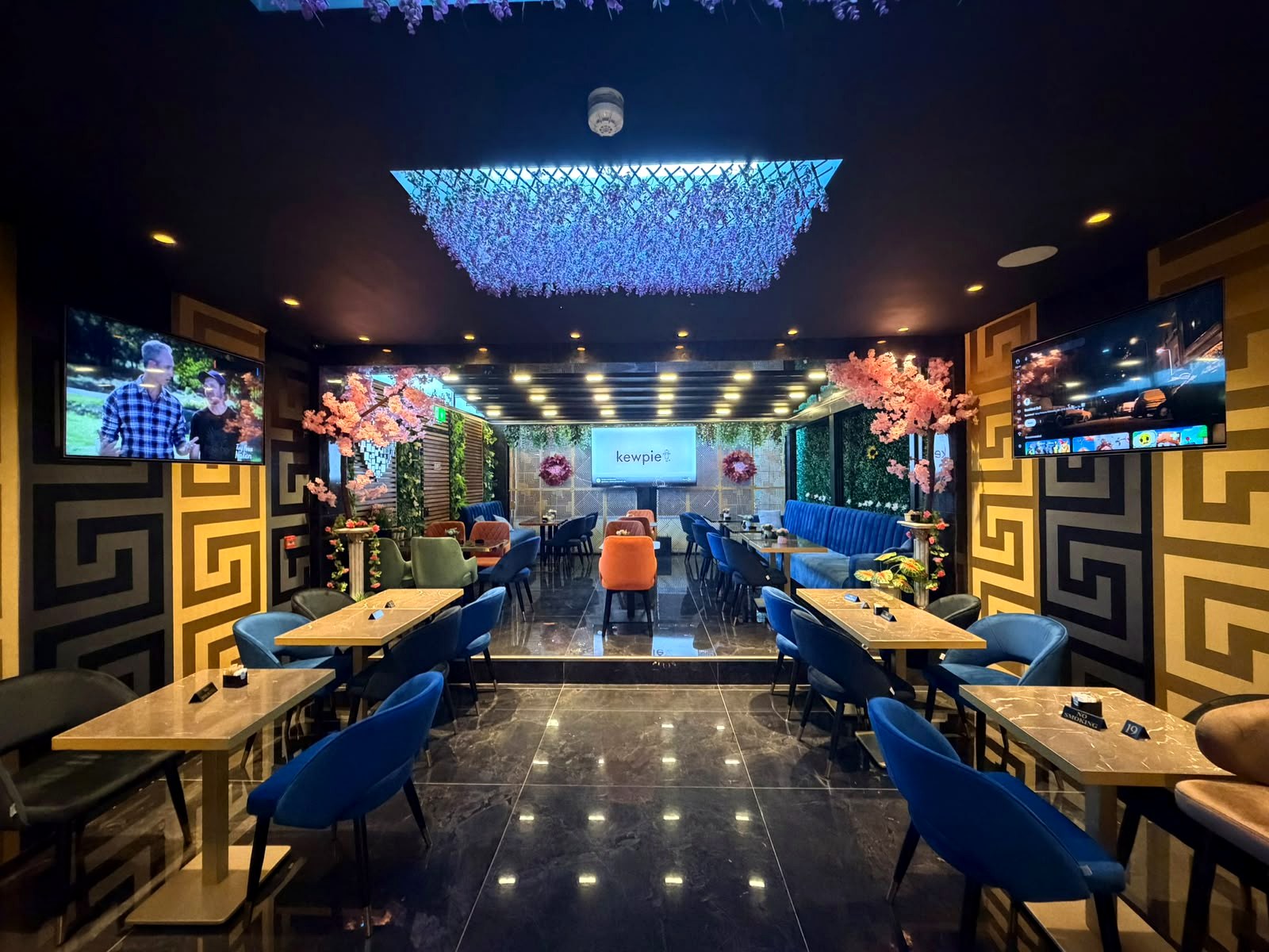 Inside Oltian in Hendon, with blue seating and hanging flowers